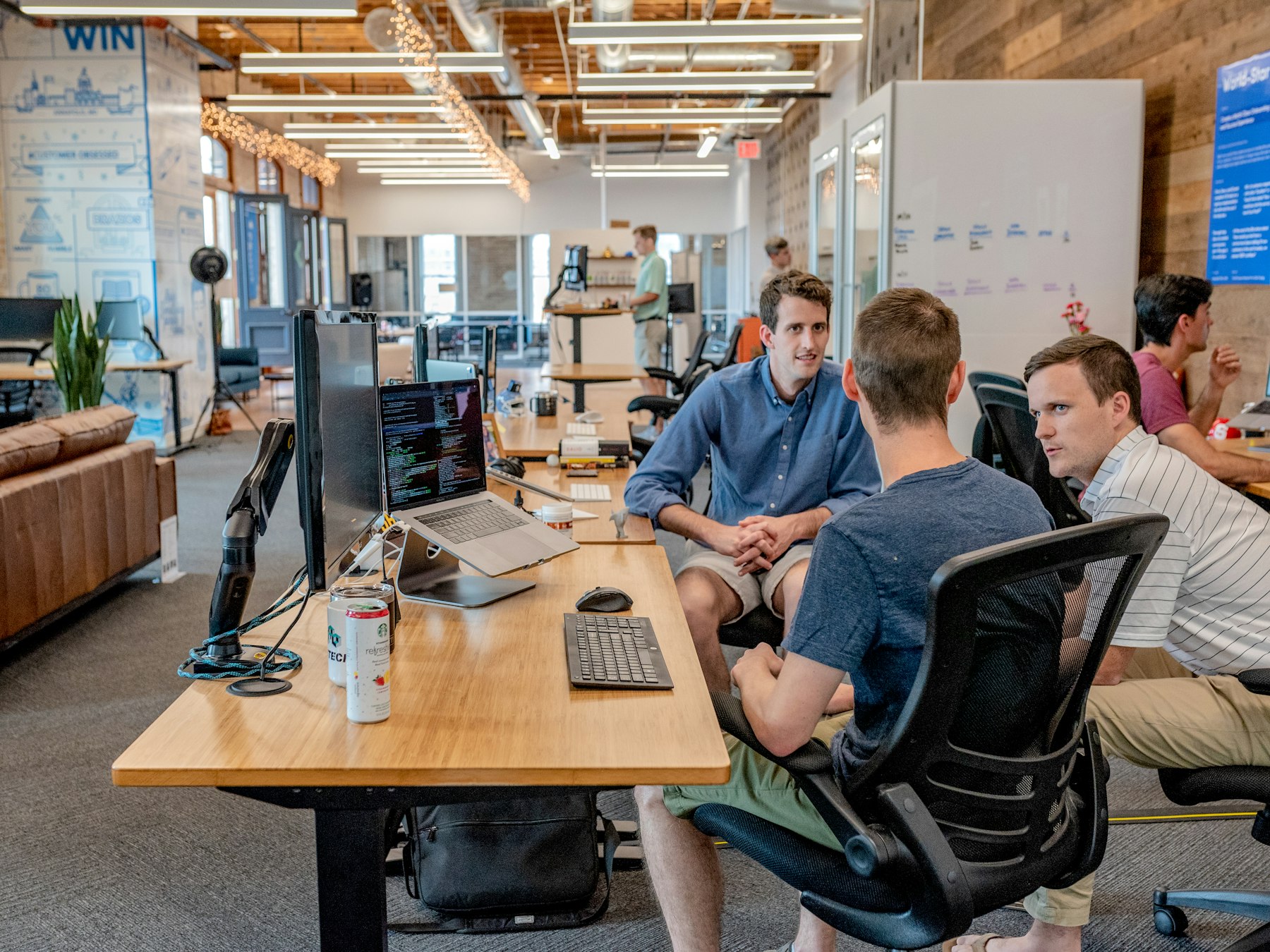 Founders in conversation around a desk in a startup workspace