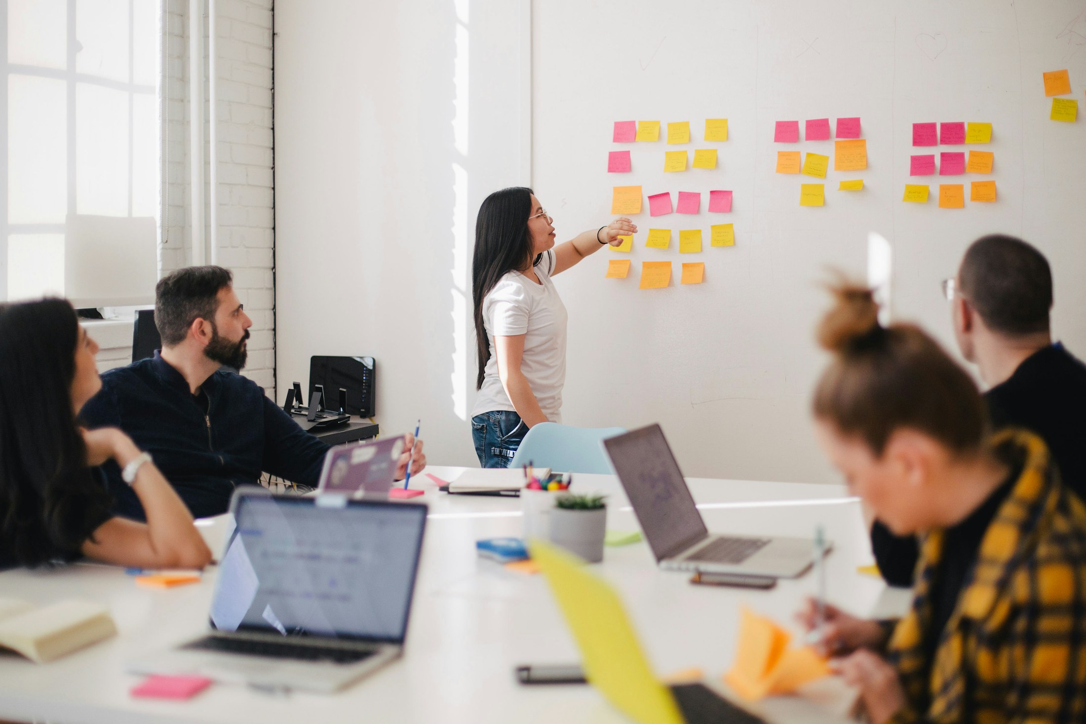 A strategy group mapping market ideas on a wall of sticky notes