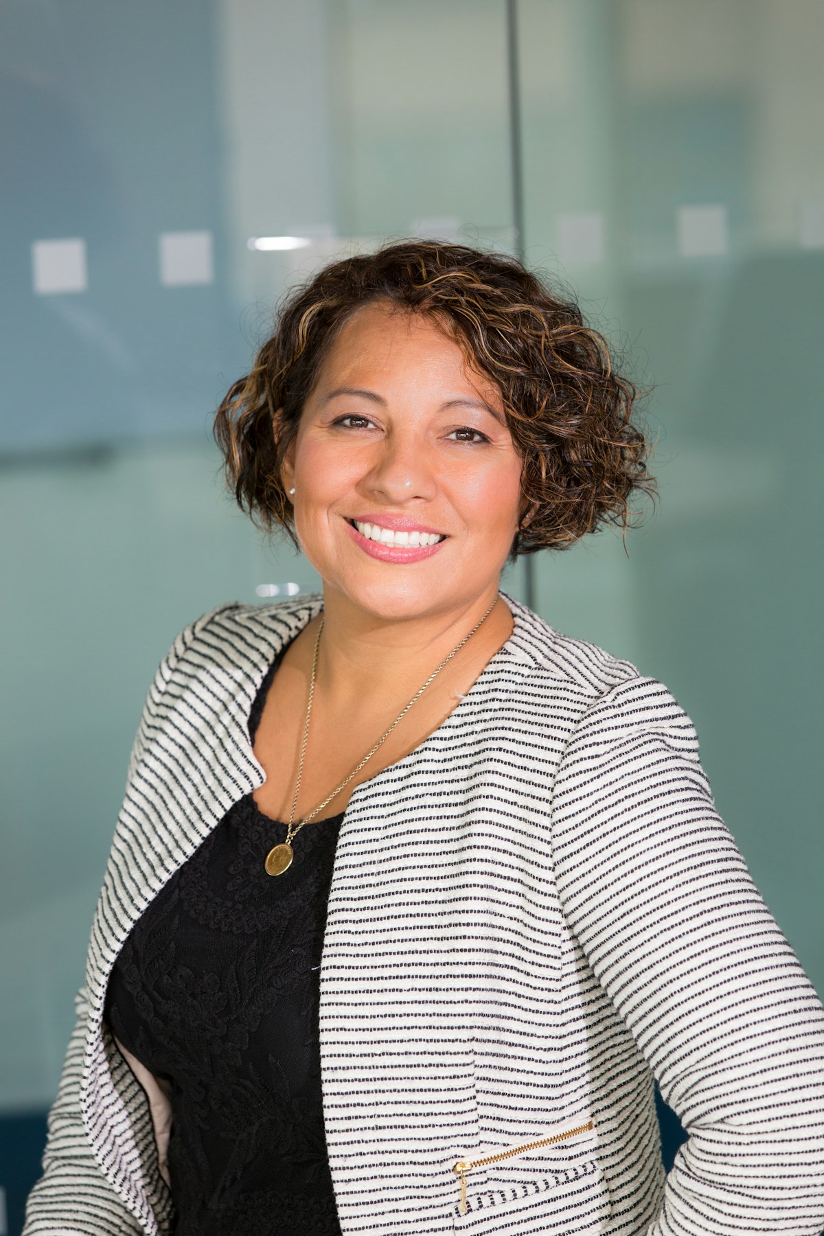 A smiling program mentor standing in an office